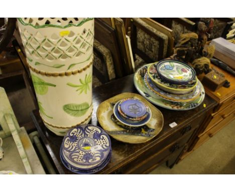 A pottery stick stand and a quantity of various pottery plates and chargers 