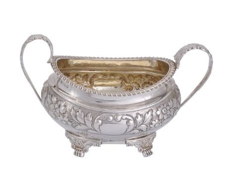 A George IV silver twin handled oval sugar basin, maker's mark worn, London 1822, with leaf and flower-capped loop handles, a