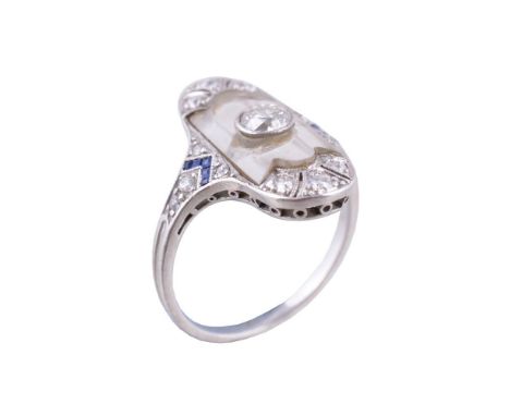 A 1920s diamond, sapphire and rock crystal panel ring, the oval shaped panel with a central old brilliant cut diamond upon a 