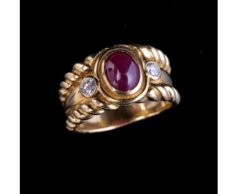 A ruby and diamond dress ring, the central oval cabochon ruby flanked by two brilliant cut diamonds, approximately 0.20 carat