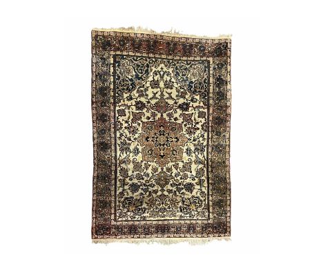 A Persian Isfahan rug, the central lotus flower shaped medallion with radiating foliate tendrils, on a cream field, 140 by 20