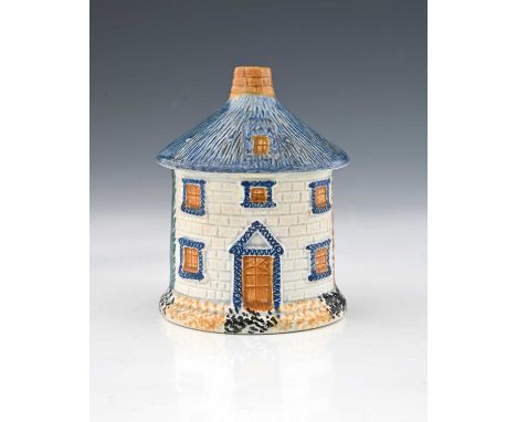 A Staffordshire Prattware thatched cottage money box, circa 1820, modelled in relief as a cylindrical house, sponge decorated