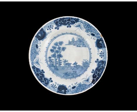 An Irish Delft blue and white plate, circa 1770, painted with deer in a Chinese garden landscape, within butterfly, cloud and