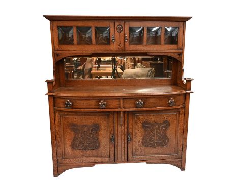 An Arts and Crafts oak sideboard, circa 1905, raised back with plain cornice over twin cupboards with convex glazing, mirror 