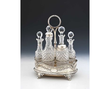 A Victorian Neoclassical-style cruet set, with six cut glass bottles, the stand with wood base and pierced gallery border, He