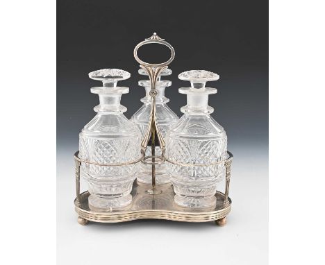 A George III silver-mounted three-bottle decanter stand, the trefoil stand with fixed central handle and loop terminal, atop 