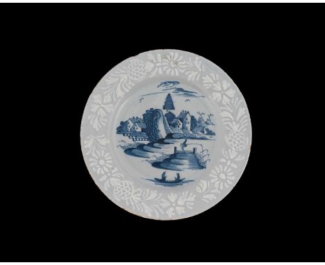 A Bristol Delft bianco sopra bianco plate, circa 1750, painted with a Chinese landscape with fisherman, within floral slip gl