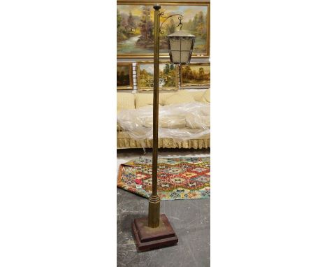 Brass stained wood and glass lantern-style standard lamp, the panelled brass and glass lantern supported on scroll, the brass