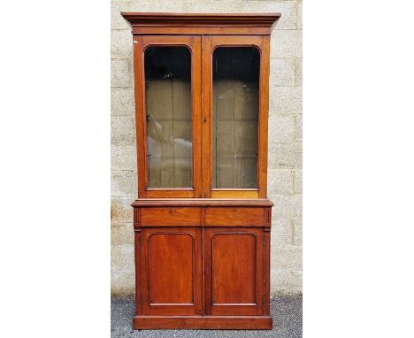 Edwardian mahogany bookcase with glazed double doors above two frieze drawers and double panelled cupboard doors, revealing s