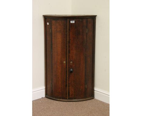 George III oak and mahogany banded bow front corner cabinet. W57cm