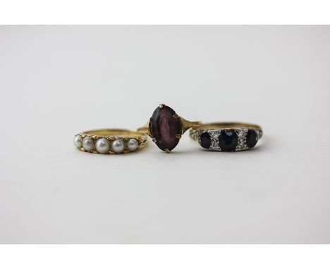 A sapphire ring; a five bead pearl ring and an amethyst dress ring