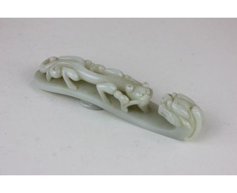 A Chinese mutton fat jade coloured glass hook modelled as a large and small dragon