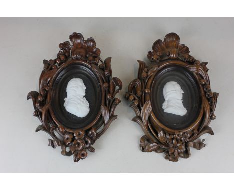 A pair of Tassie white plaster portrait profiles of Adam Smith and Sir John Sinclair, in glazed oval frames with ornately car