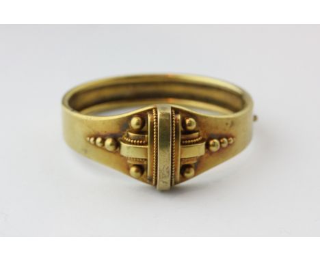 A late 19th century gold bangle with beaded centre panel
