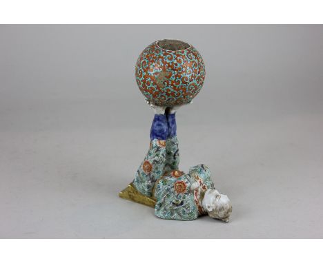 A Chinese porcelain pin cushion, in the form of an acrobat, balancing a ball on his feet, marks to base (a/f) 17cm high (NC)