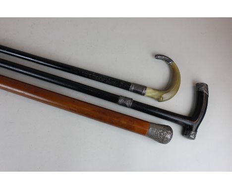 A silver mounted ebonised walking stick, a silver mounted horn handled walking stick and a silver mounted cane