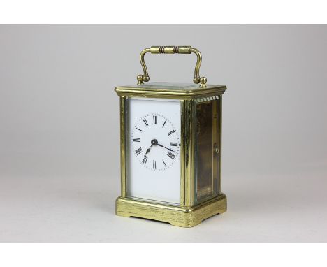A brass and bevelled glass cased carriage clock the white enamelled face with Roman numerals 14cm high 