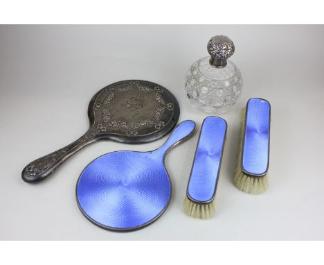 A George V silver and blue enamel backed dressing table set of hand mirror, and two clothes brushes, together with another si