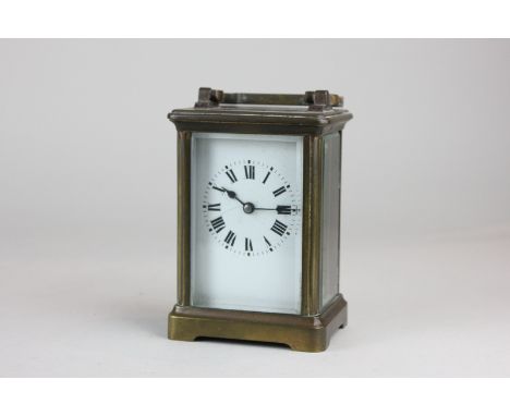 A brass and bevelled glass cased carriage clock with Roman numerals, the movement marked, made in France (a/f) 15cm