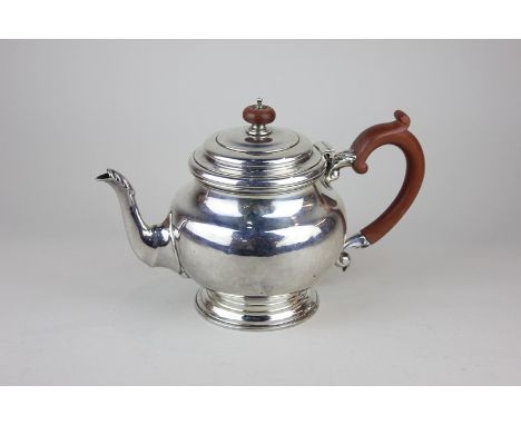 A George V silver teapot with plain globular body and embossed leaf decoration to handle and spout, maker EB,London 1932, 20o