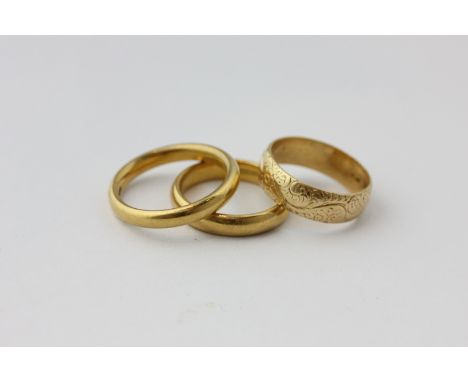 Two 22ct gold wedding bands, 5.6g; and an 18ct gold engraved ring, 3.9g