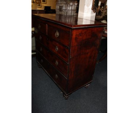 A 19th century mahogany chest, of two short over three long drawers, with brass ring handles, on turned legs