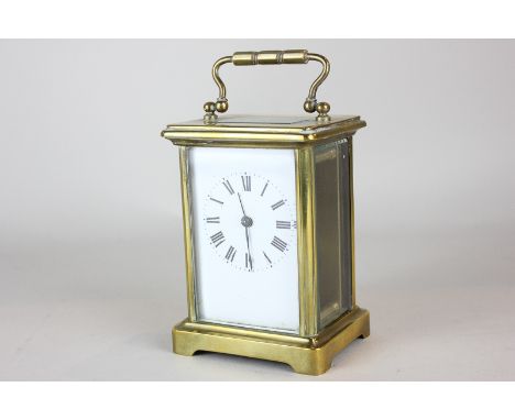 A French brass and bevelled glass cased carriage clock the white enamel face with Roman numerals, 14cm