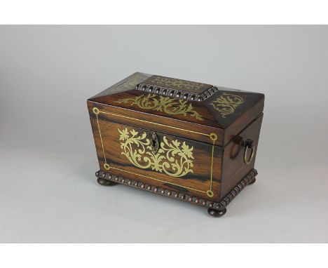 A Victorian brass inlaid rosewood tea caddy, of sarcophagus form with egg and dart moulding, with two-division interior and c