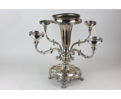 A silver plated table candlestick with central vase and four scroll branches, on base with scroll borders, raised on four fee