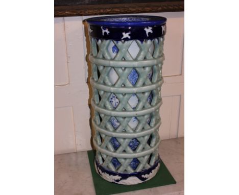 A Chinese porcelain reticulated stick stand the inner cylinder with blue and white decoration of birds in foliage, the outer 