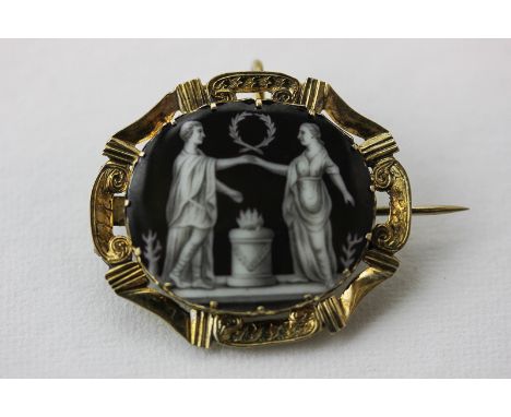 A gold and enamel mourning brooch the oval panel enamelled on copper with a classical scene, hair compartment to the reverse
