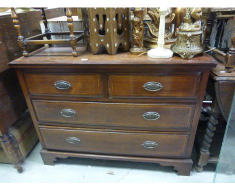 A mahogany inlaid chest of two short over two long drawers raised on bracket feet