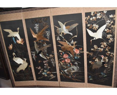 Japanese four-fold silk screen embroidered with cranes and other birds perches amongst flowering blossom branches on a black 