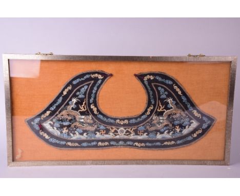 C19th Chinese embroidered panel, woven with a pair of confronted dragons chasing a flaming pearl amidst clouds and waves, wit