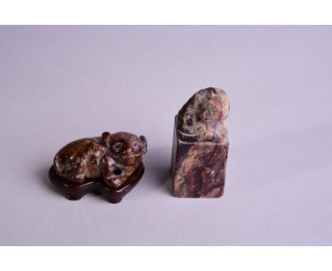 Chinese russet jade carving of a recumbent dog, wood stand, 5cm wide; together a hardstone seal with a lion finial (2) 