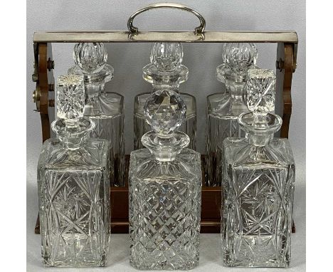 20TH CENTURY SILVER PLATED & MAHOGANY THREE-BOTTLE TANTALUS & THREE FURTHER CUT GLASS DECANTERS, the tantalus with click lock