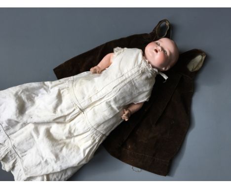 A ceramic doll marked AM Germany 351./2.K., with brown velvet dress.