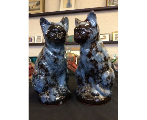 Two 'Ewenny Pottery' ceramic cats in mottled blue and brown design, engraved on base and label titled 'St Fagans'. Height 34c