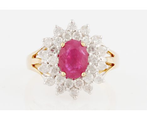 A 9ct yellow gold treated ruby and diamond cluster ring, set with an oval cut ruby, possibly glass filled, measuring approx. 