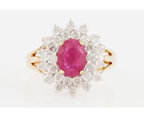 A 9ct yellow gold treated ruby and diamond cluster ring, set with an oval cut ruby, possibly glass filled, measuring approx. 