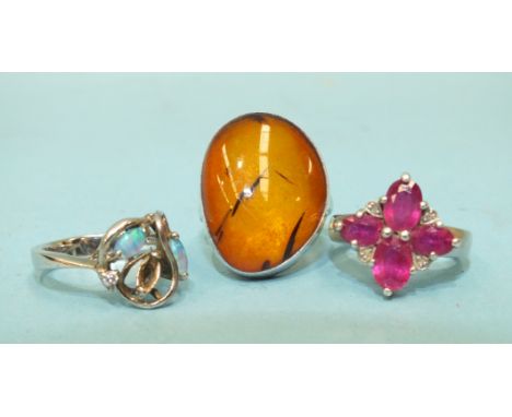 A ruby and diamond point cluster ring with silver mount, a silver ring set two opals, (one setting vacant) and an amber-set s