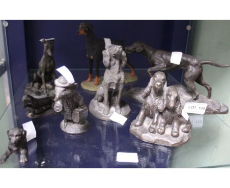 A shelf containing a selection of bronze effect figures of mainly dogs