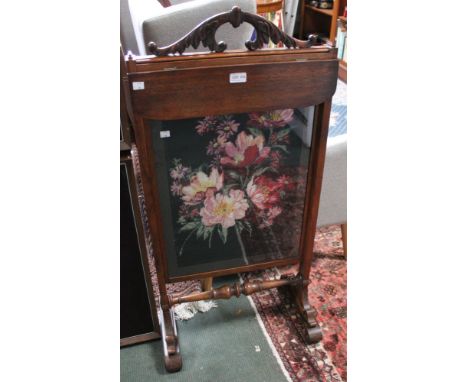 A mahogany free standing tapestry fire screen with folding shelf