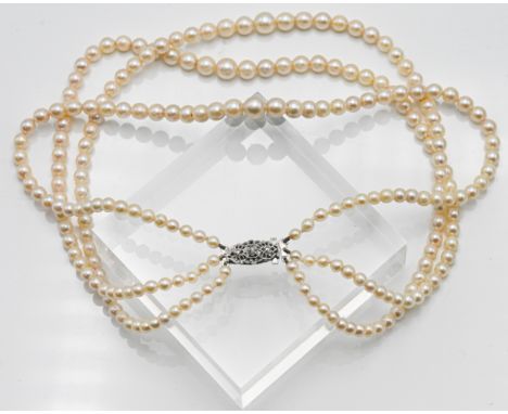 Graduated three row cultured pearl necklace, approx. length: 40cm, pearl size 4.50-7.00mm with a silver pierced clasp set wit