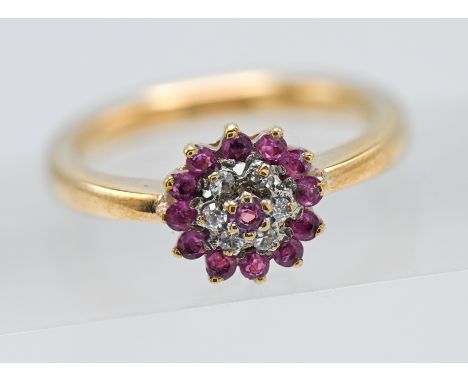 18ct ruby &amp; diamond round shaped cluster ring. Central ruby surrounded by six round cut diamonds with an outer border of 