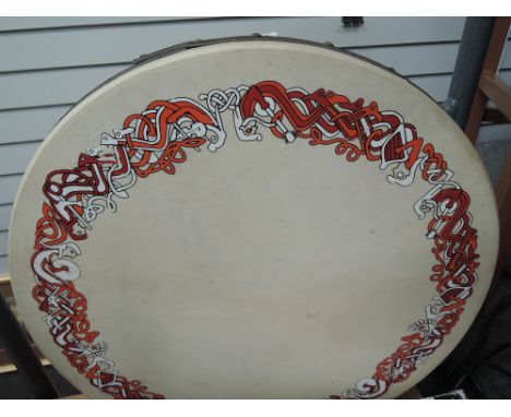 A traditional Bodhran , having red and orange Celtic pattern