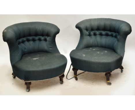 A pair of late Victorian shaped button backed tub chairs raised on ring turned front legs to brass caps and castors, the rear