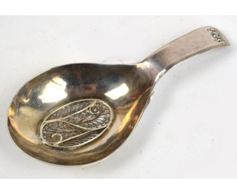 A George III hallmarked silver caddy spoon with oval bowl centred with filigree decorated section and with engraved initials 