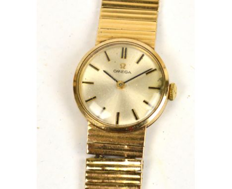OMEGA; a ladies 9ct gold cased mechanical wrist watch with circular dial set with baton numerals, on integrated 9ct gold brac