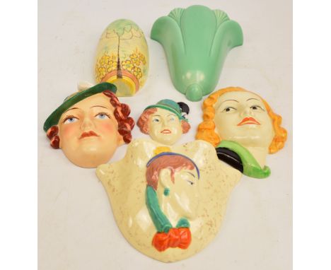 Three Art Deco style ceramic masks depicting women, a similarly decorated wall pocket, and two further wall pockets (6). COND
